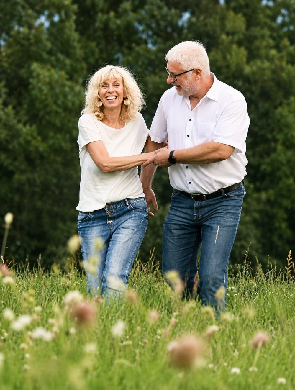 Marion und Matthias Christ lachend auf einer Sommerwiese